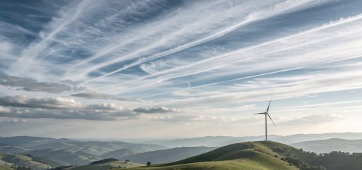 Illustration réaliste d’un paysage avec des nuages superposés, des flux d’air visibles dans le ciel et une éolienne au loin.